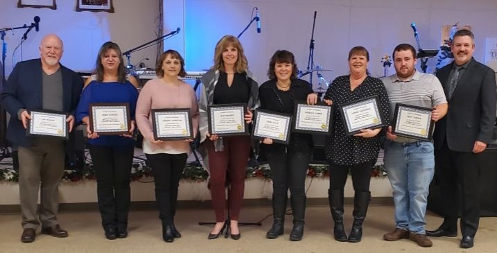 A group of people are standing next to each other holding certificates.