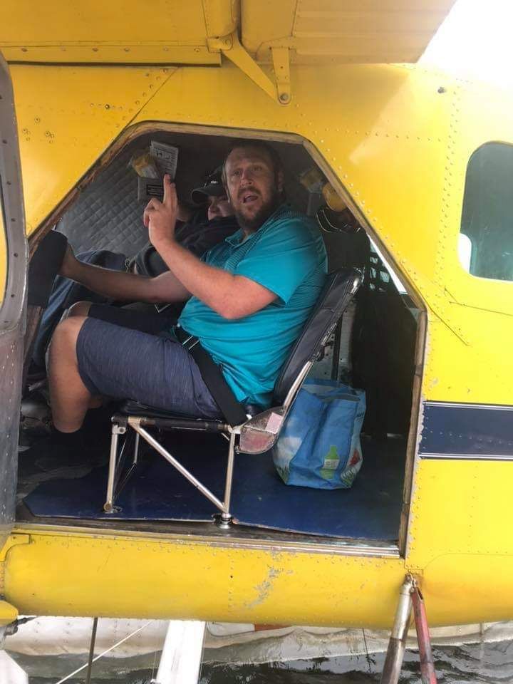 A man in a blue shirt is sitting in a yellow airplane.