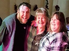 A man and two women are posing for a picture together.