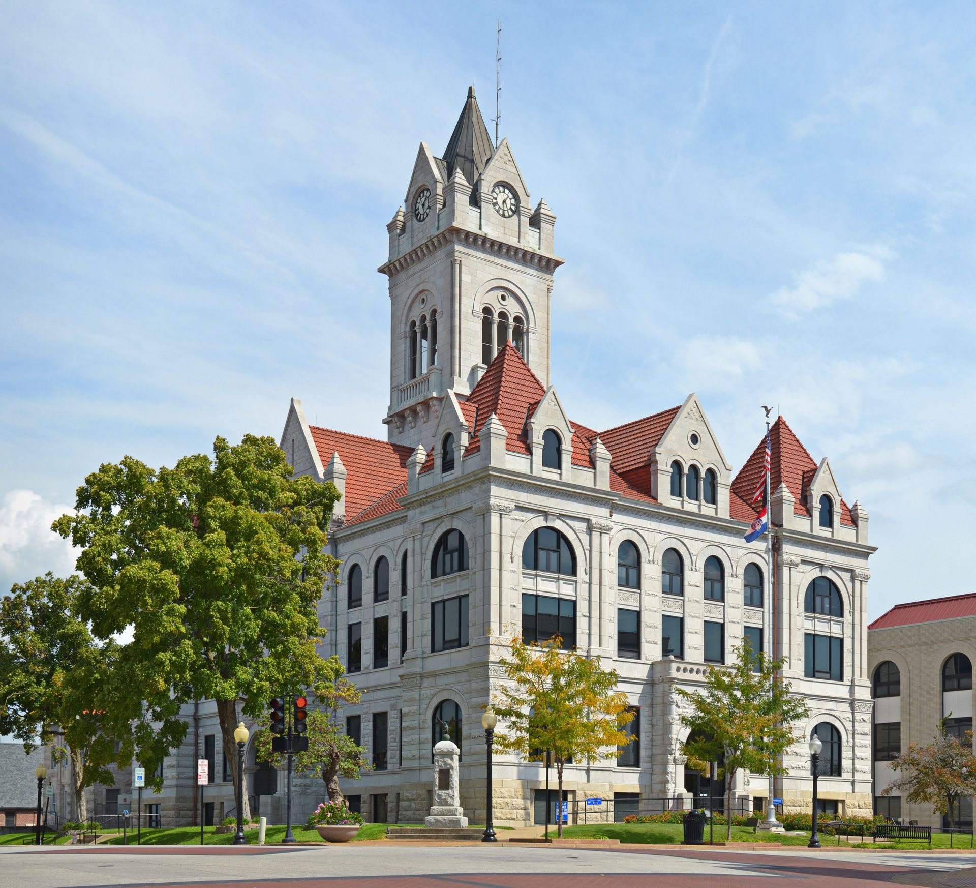 Picture of Cole County Courthouse. A Gray granite building with red roofing and multiple gables.