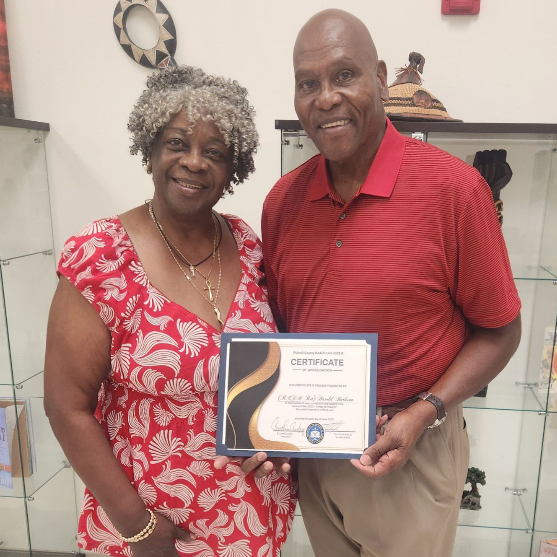Woman and man stand together holding certificate of appreciation.