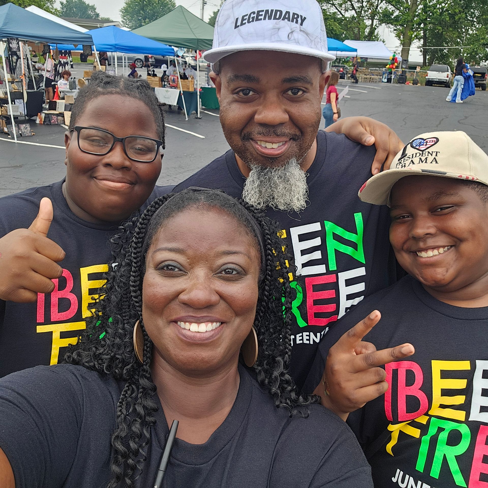 A group of people posing for a picture with one wearing a hat that says legendary