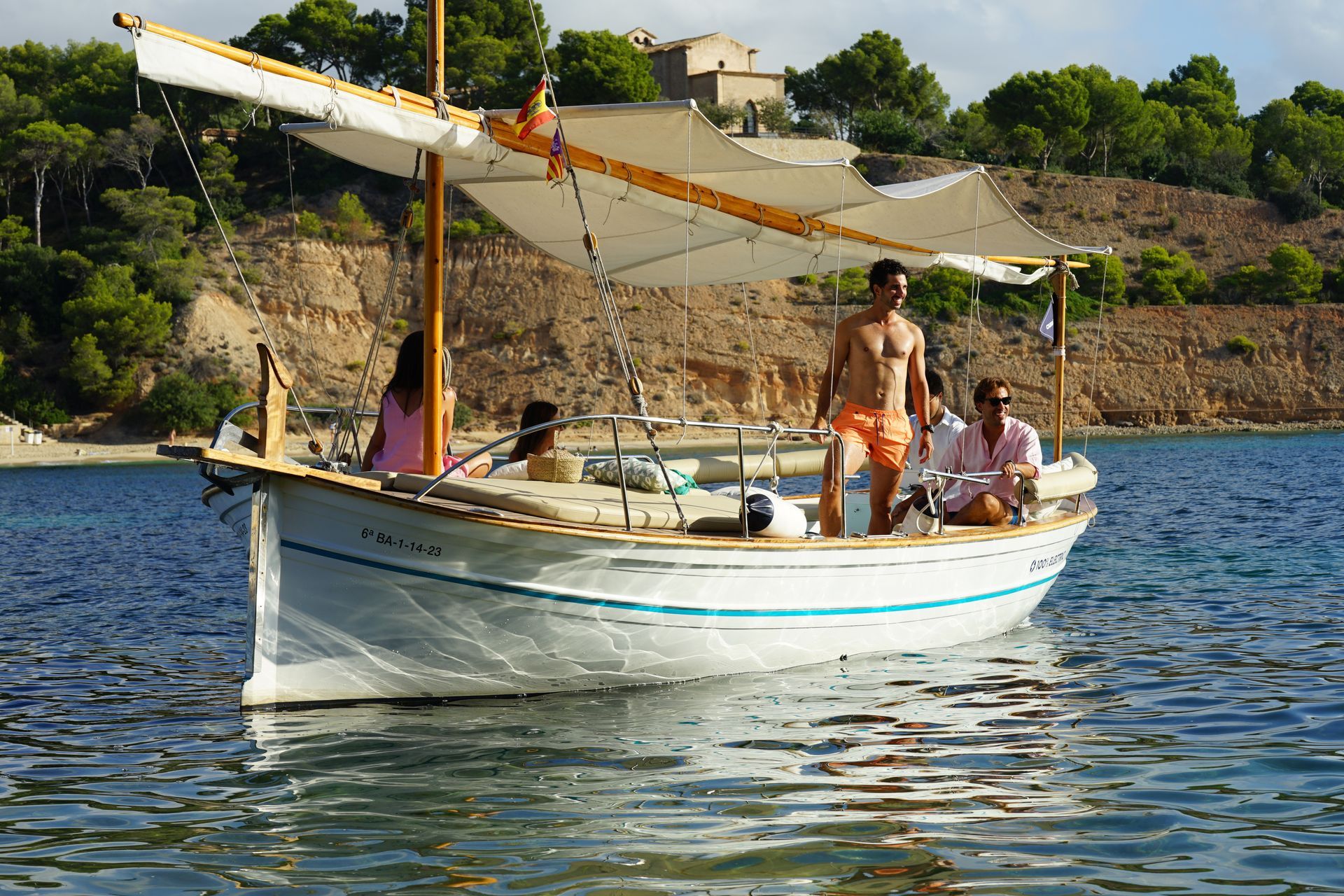 Pareja disfrutando de un romántico paseo en llaut mientras conversan en el mar de Mallorca