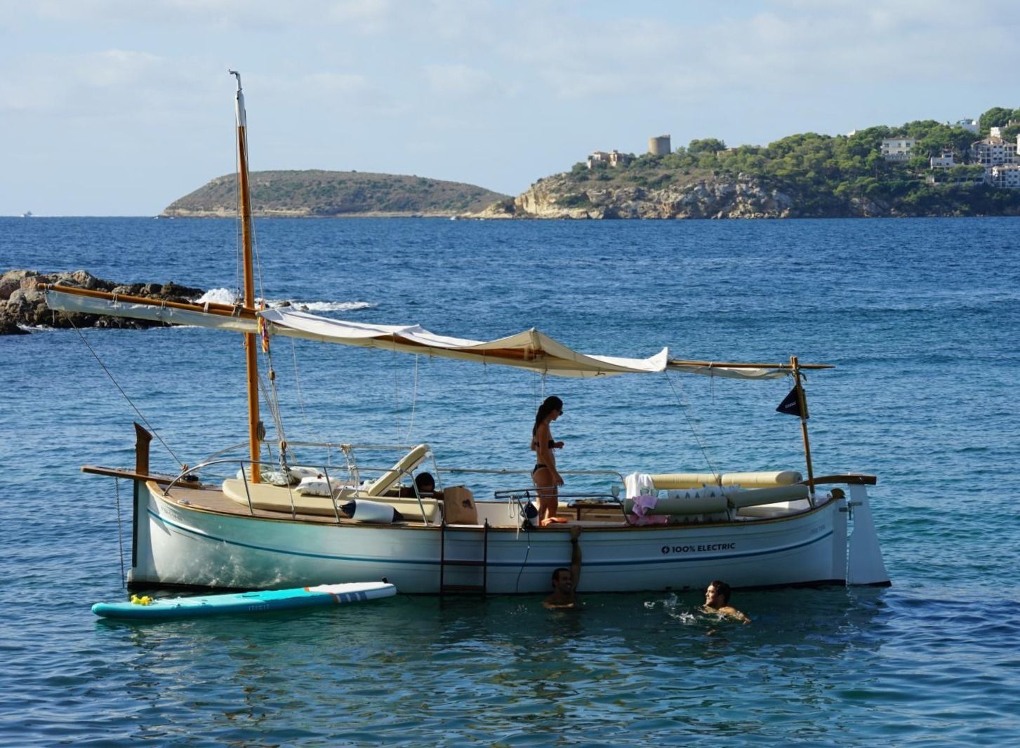 Pareja disfrutando de una comida y bebida en un romántico paseo en llaut por el mar de Mallorca