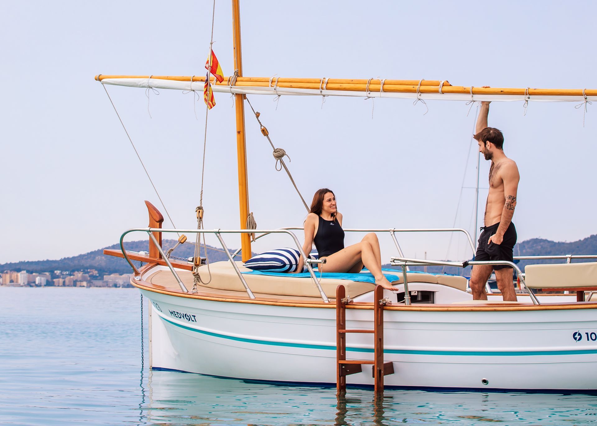 Pareja disfrutando de un romántico paseo en llaut por el mar de Mallorca, ideal para alquiler de llaut.