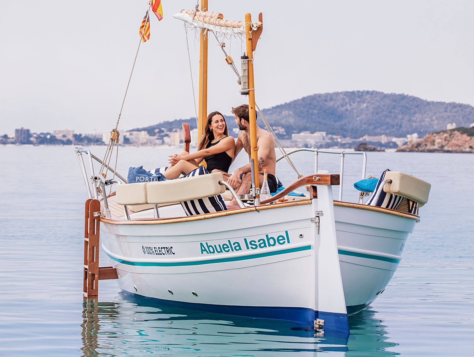 Pareja disfrutando del Full Day Tour en llaüt por la costa de Mallorca, rodeados de un paisaje romántico.
