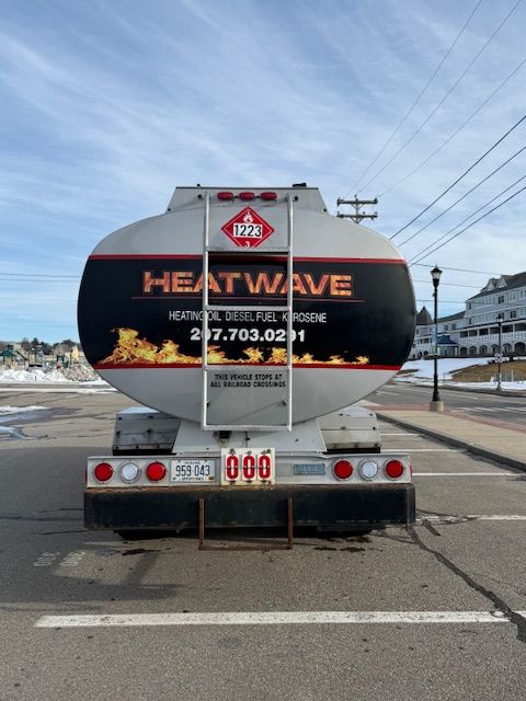 Rear view of a silver Heat Wave fuel tanker truck parked in a lot, featuring a 1223 hazardous materials placard.