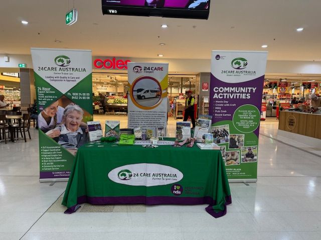 A table with a green table cloth and a sign that says community activities