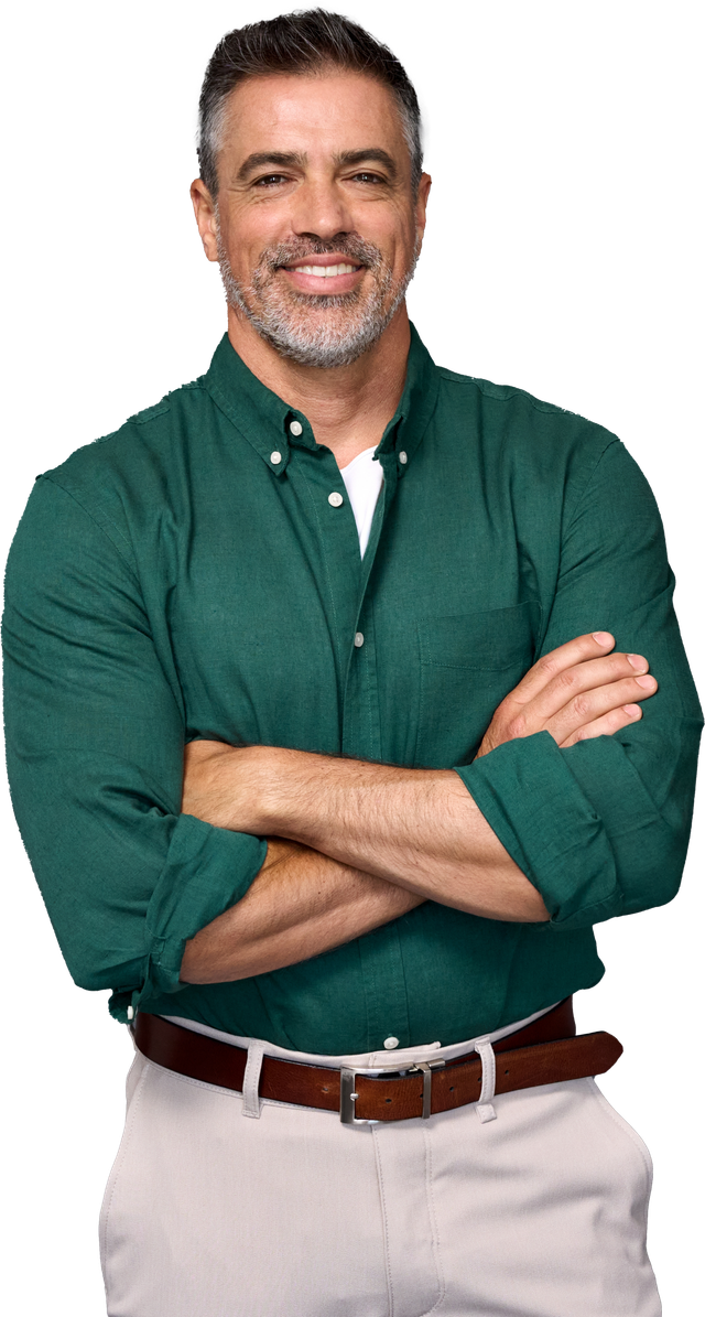 A man in a green shirt and khaki pants is standing with his arms crossed.