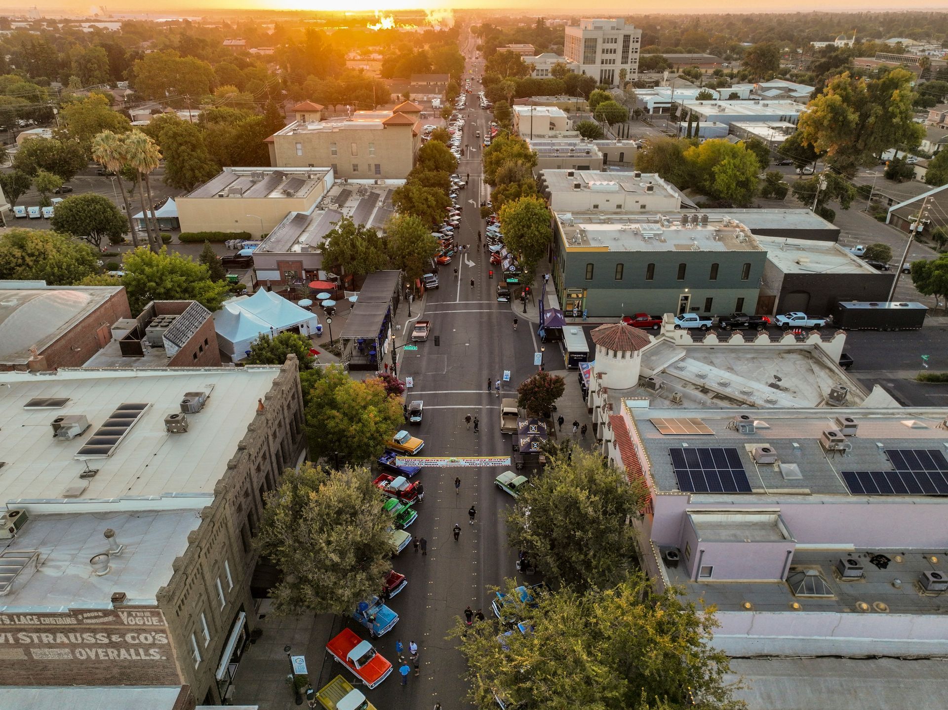Aerial view of street with cars, trees, and buildings at sunset of City of Prescott