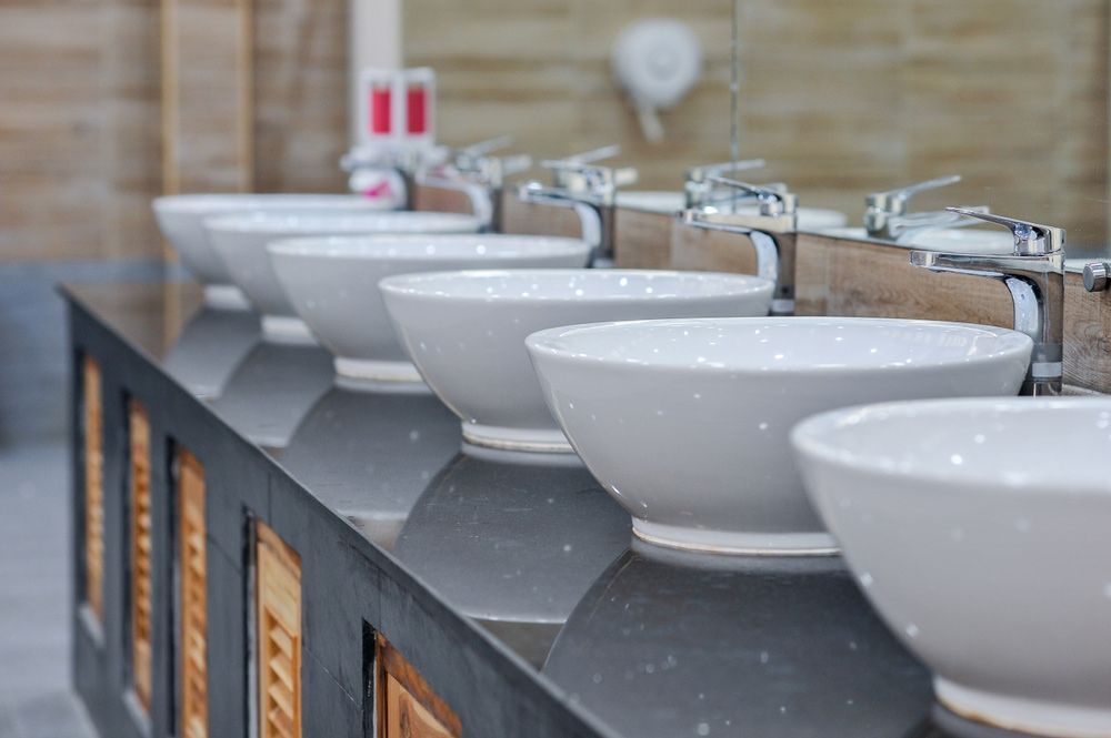 A Row of White Sinks Are Lined up On a Counter in A Bathroom — One Flush Plumbing Service In Oxenford, QLD