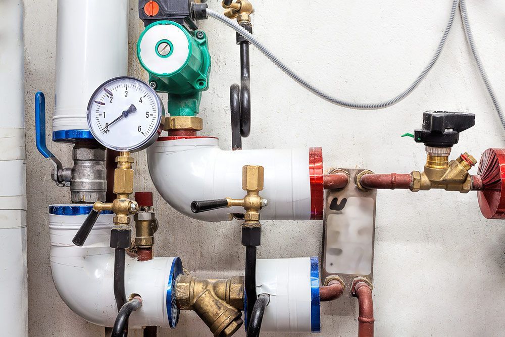 A Close up Of a Boiler Room with A Lot of Pipes and Valves — One Flush Plumbing Service In Oxenford, QLD