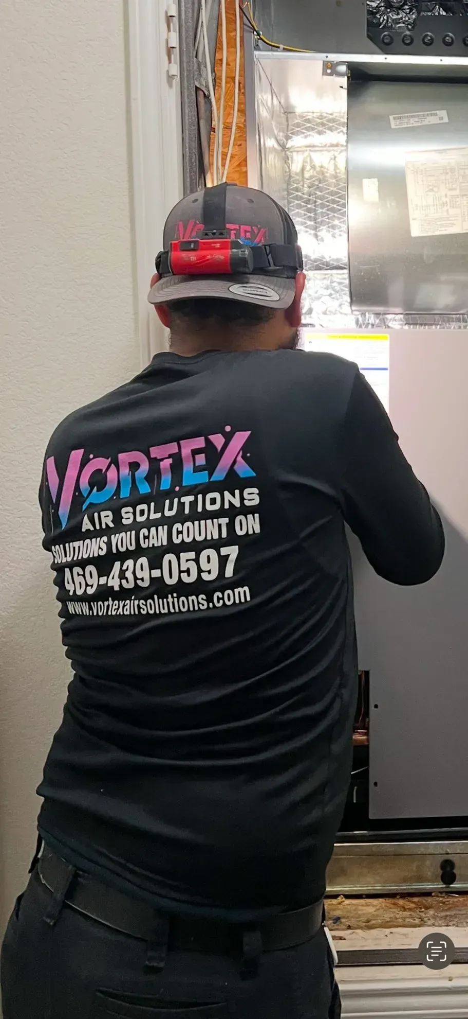 Person wearing a hat and black shirt with the logo 