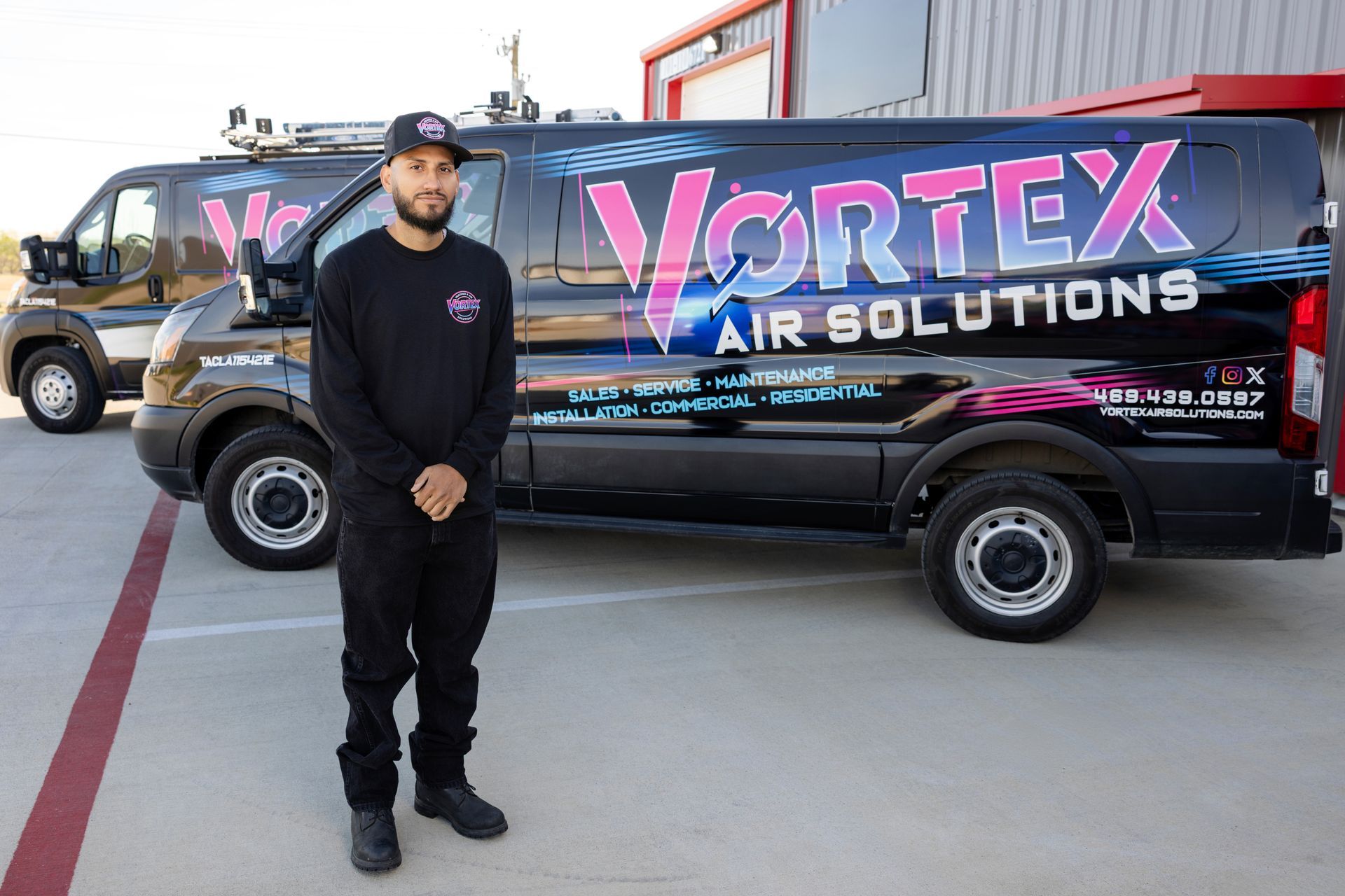 Woman relaxing on a gray sofa with arms behind her head, eyes closed.