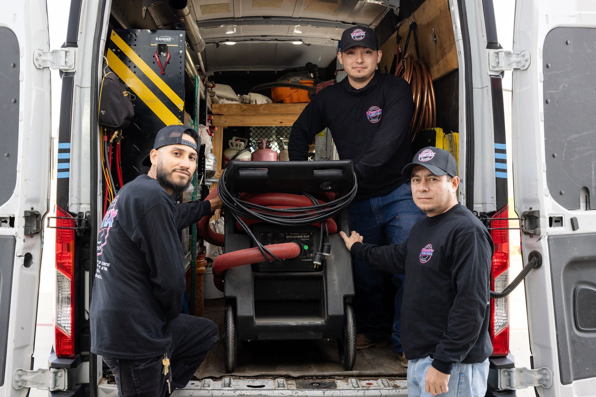 Person in gloves servicing an indoor air conditioning unit, removing the cover.