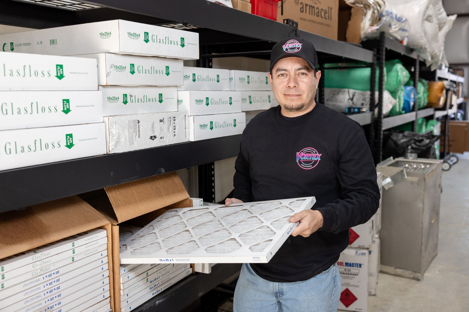 Hand holding a yellow thermometer measuring air temperature at a white vent. Reading is 70.9°F.
