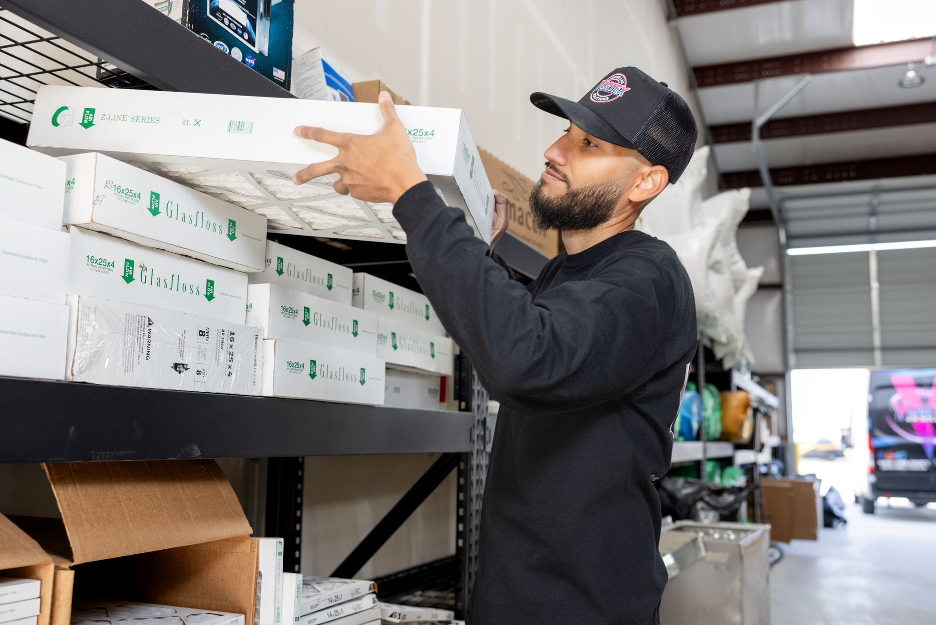 Hand replacing a rectangular air filter in a white frame.