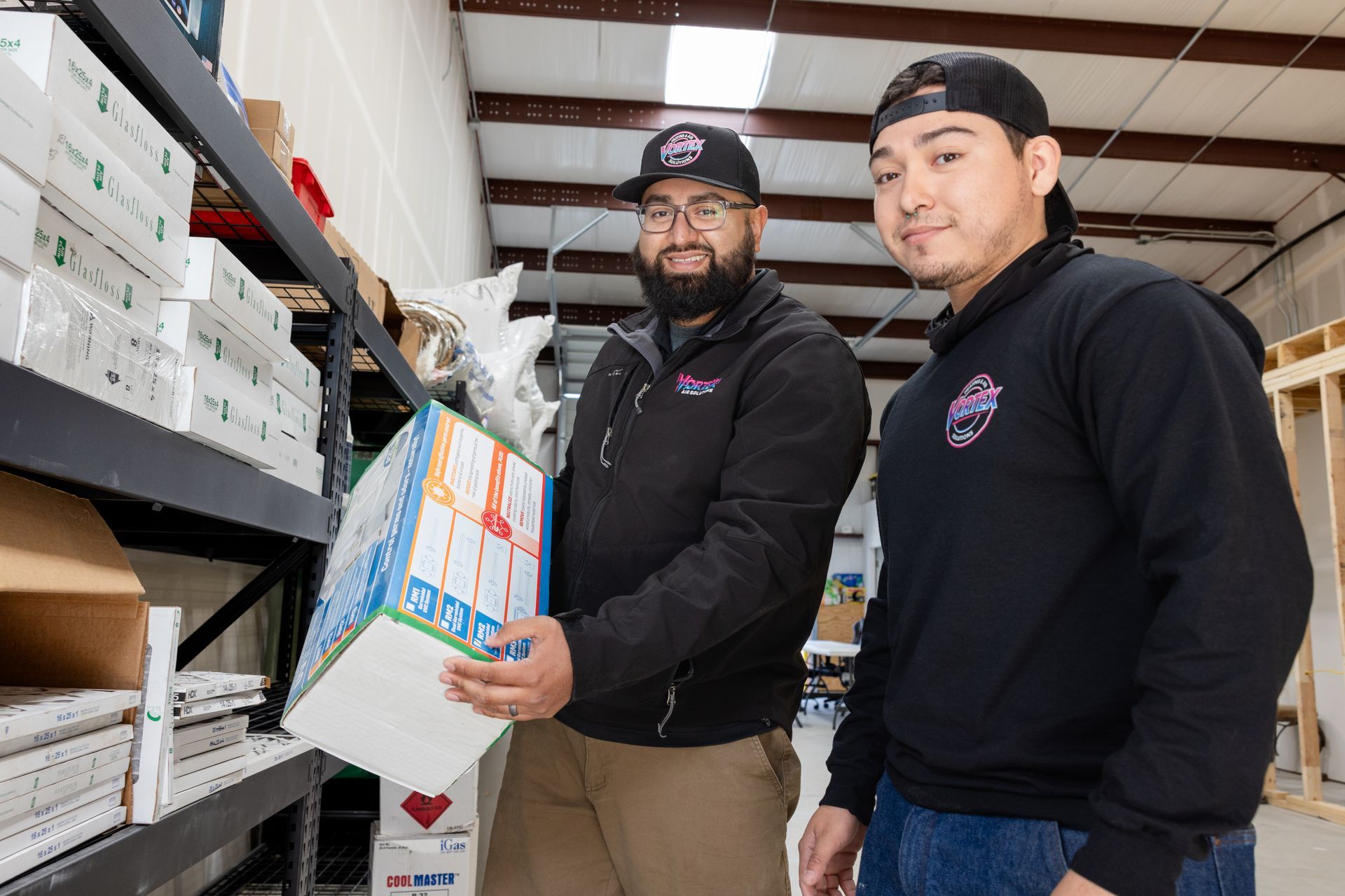 Family of four laughing on a couch. Two children hug their parents in a living room.