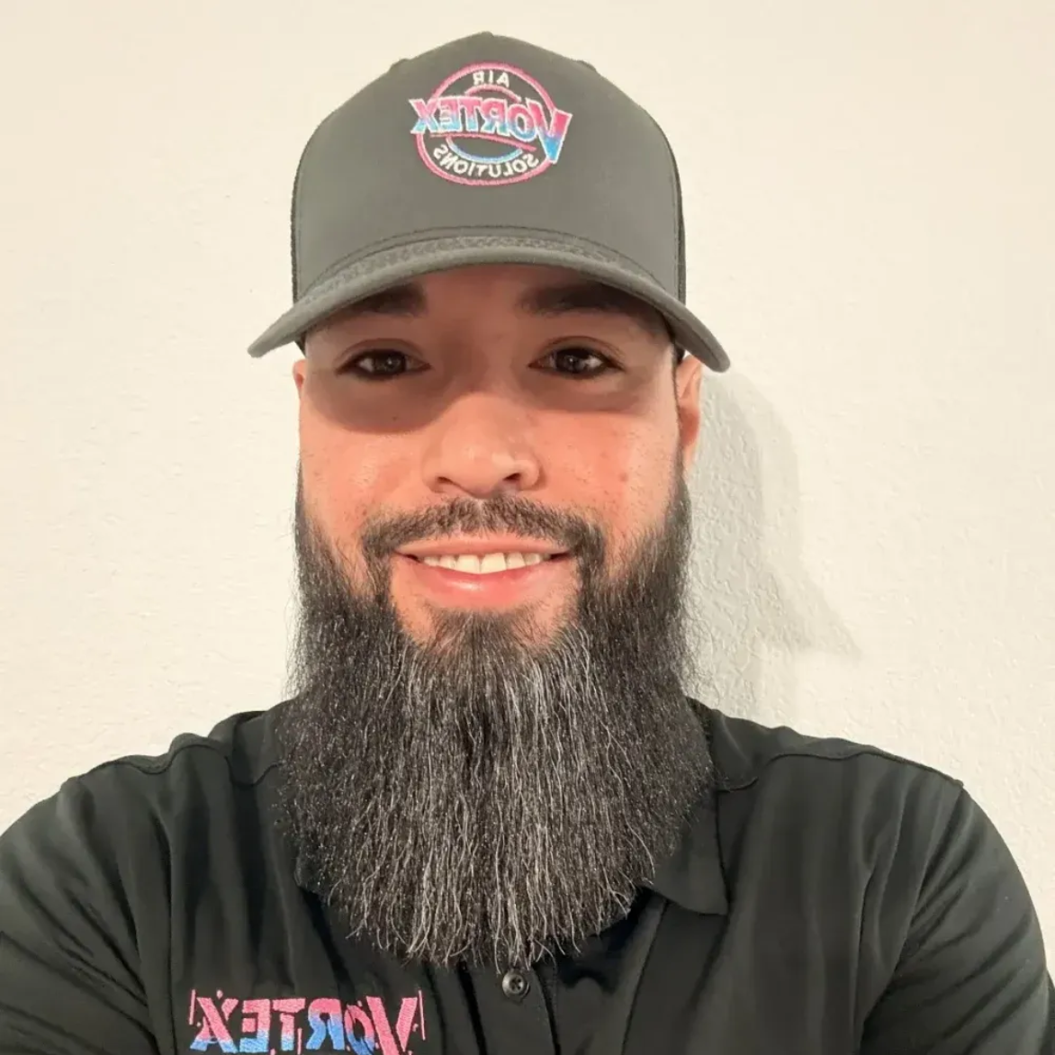 Man wearing a gray cap and black shirt with the word
