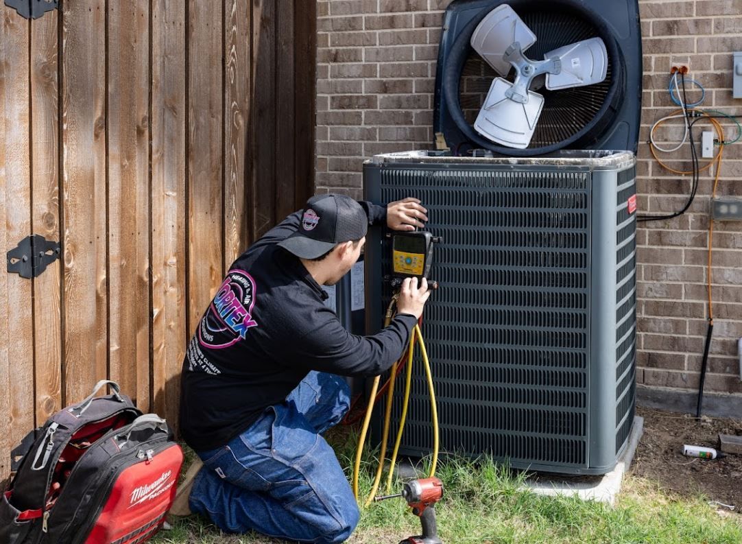 Woman adjusting a thermostat on a white wall in a modern dining room.