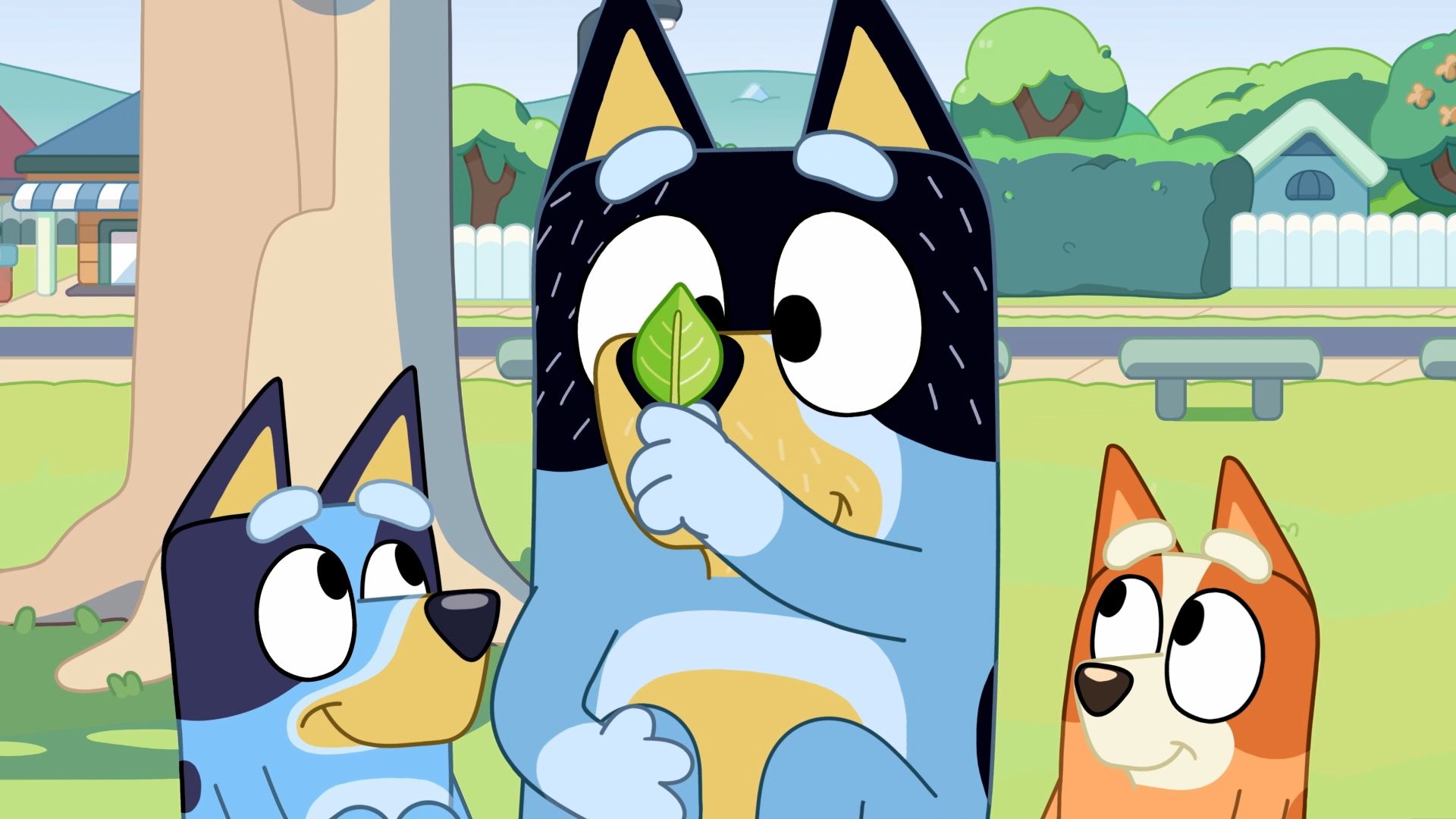 A cartoon dog is holding a leaf in his mouth while standing next to two other dogs.