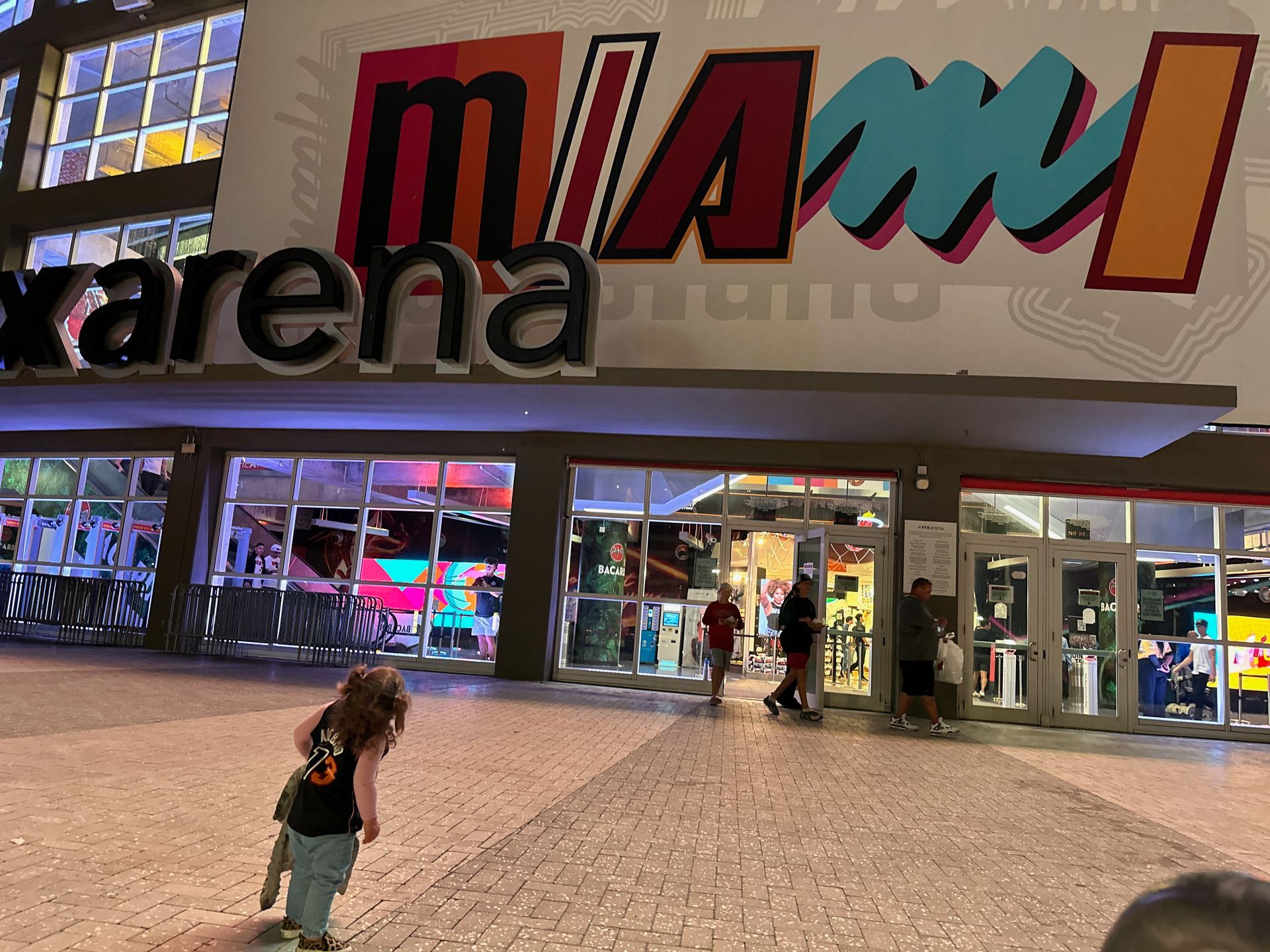 A little girl standing in front of a miami arena