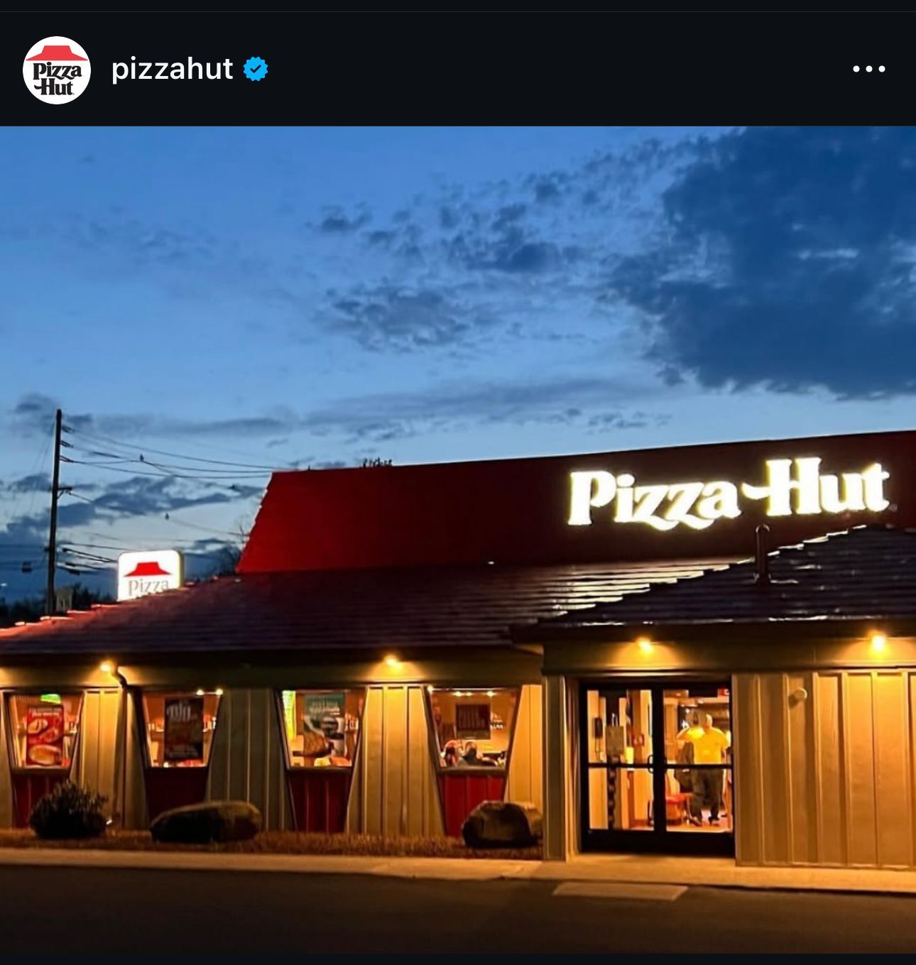 A pizza hut restaurant is lit up at night