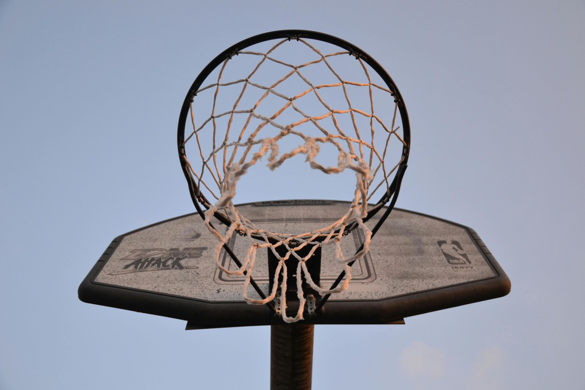 A close up of a basketball hoop against a blue sky