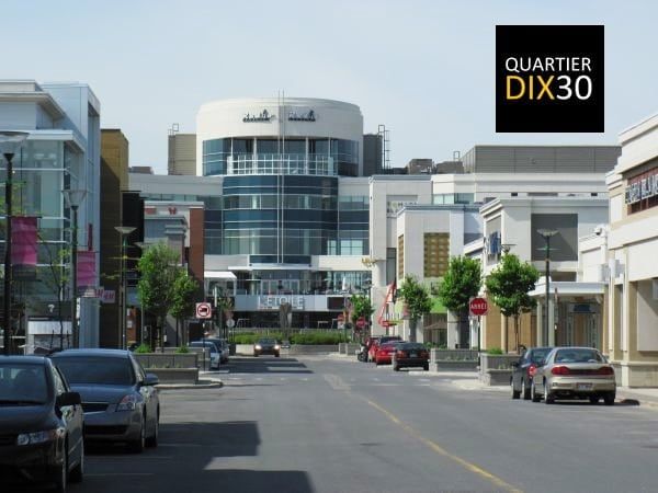 A city street with a sign that says quartier dix30