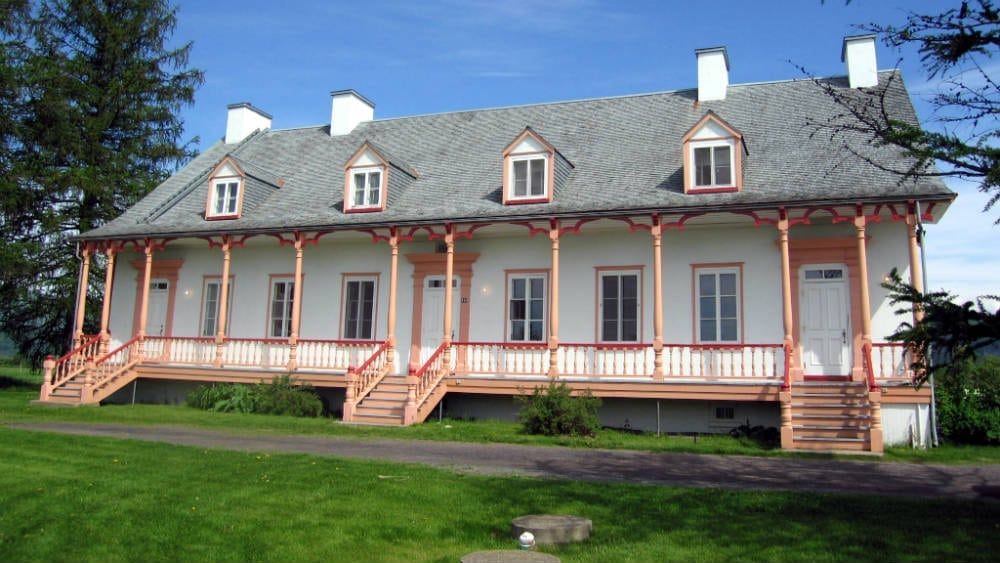 A large white house with a porch and stairs