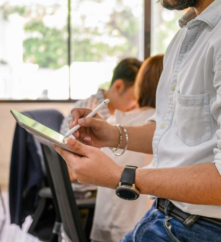 A man is holding a tablet and a pen in his hands.