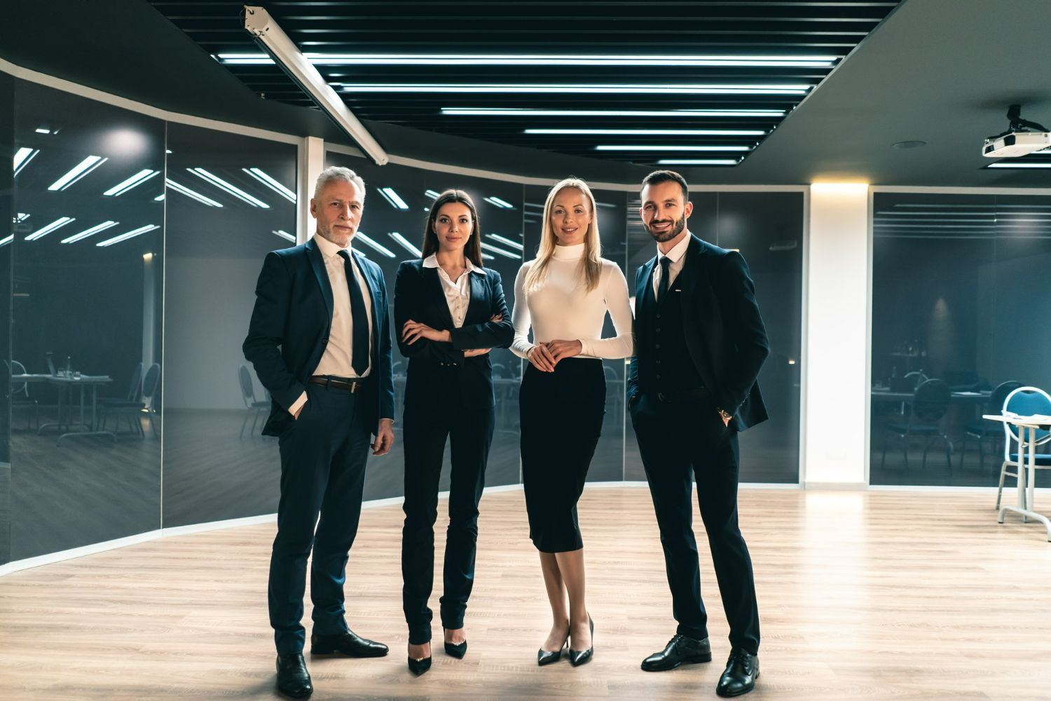 A group of business people are standing next to each other in an office.