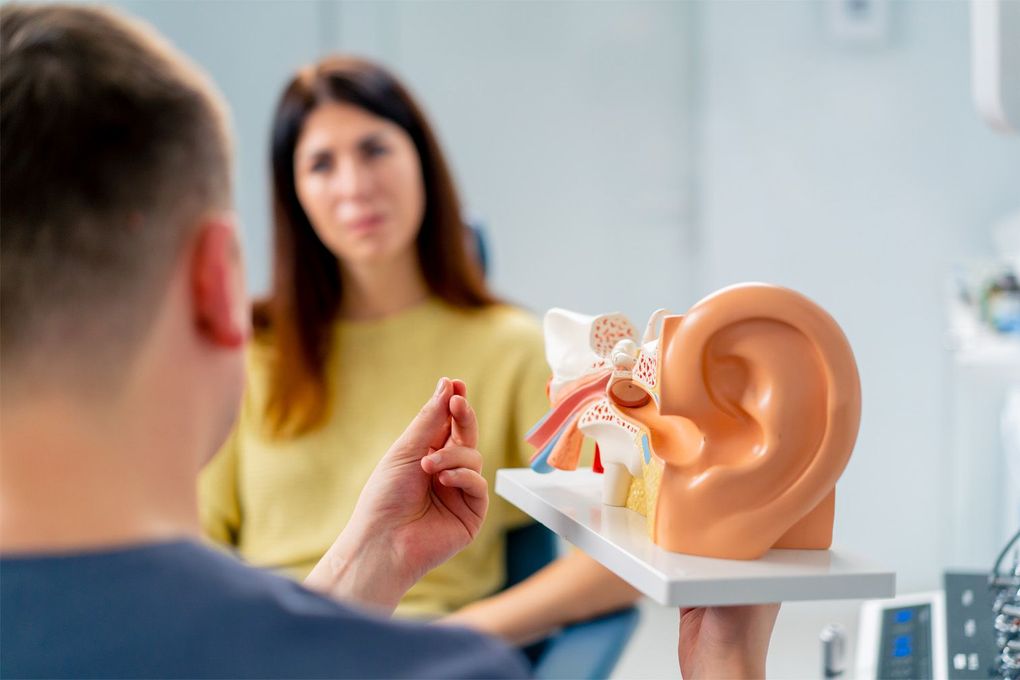 A woman is getting her ears examined by an otolaryngologist.