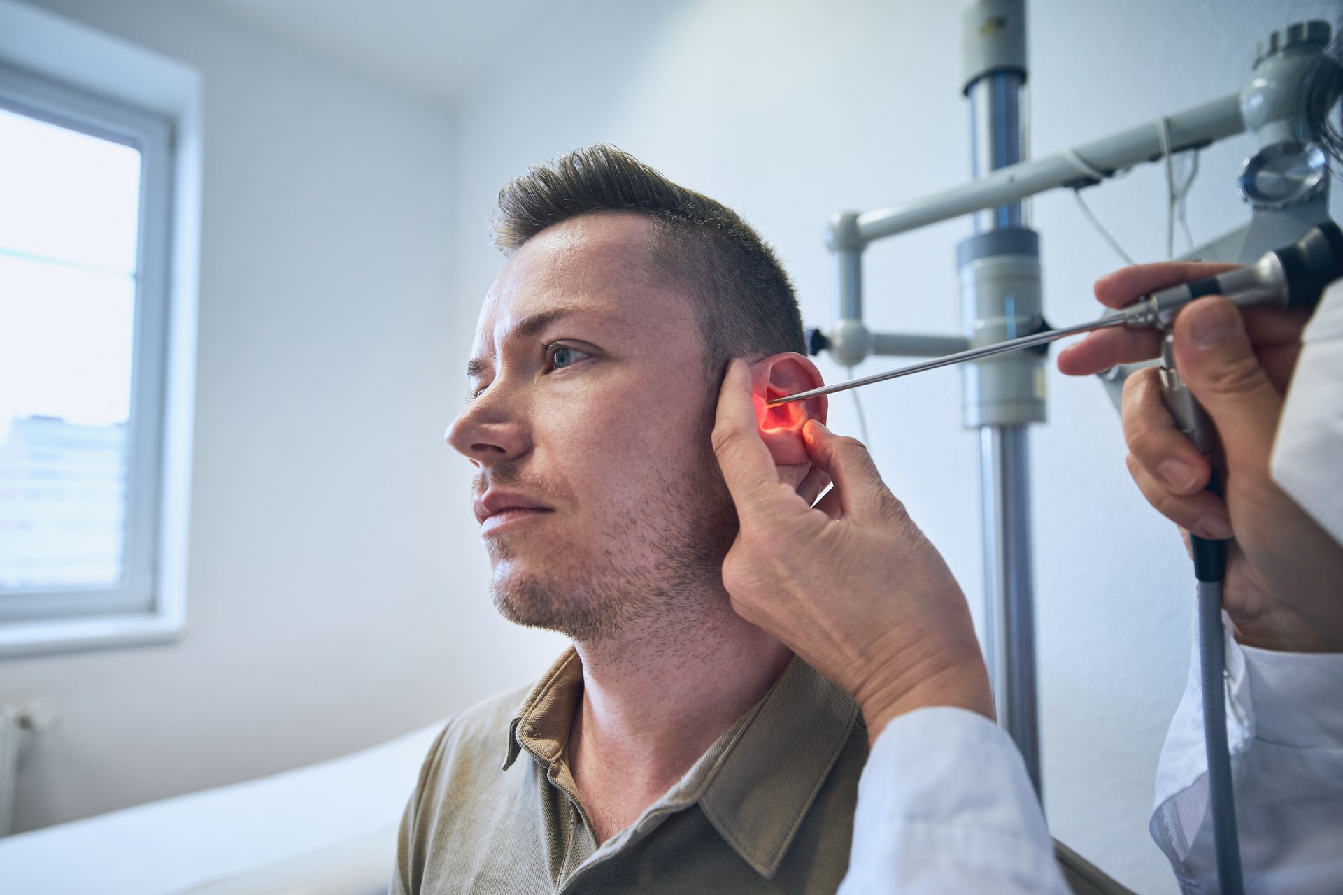 A man is getting his ear examined by a doctor.