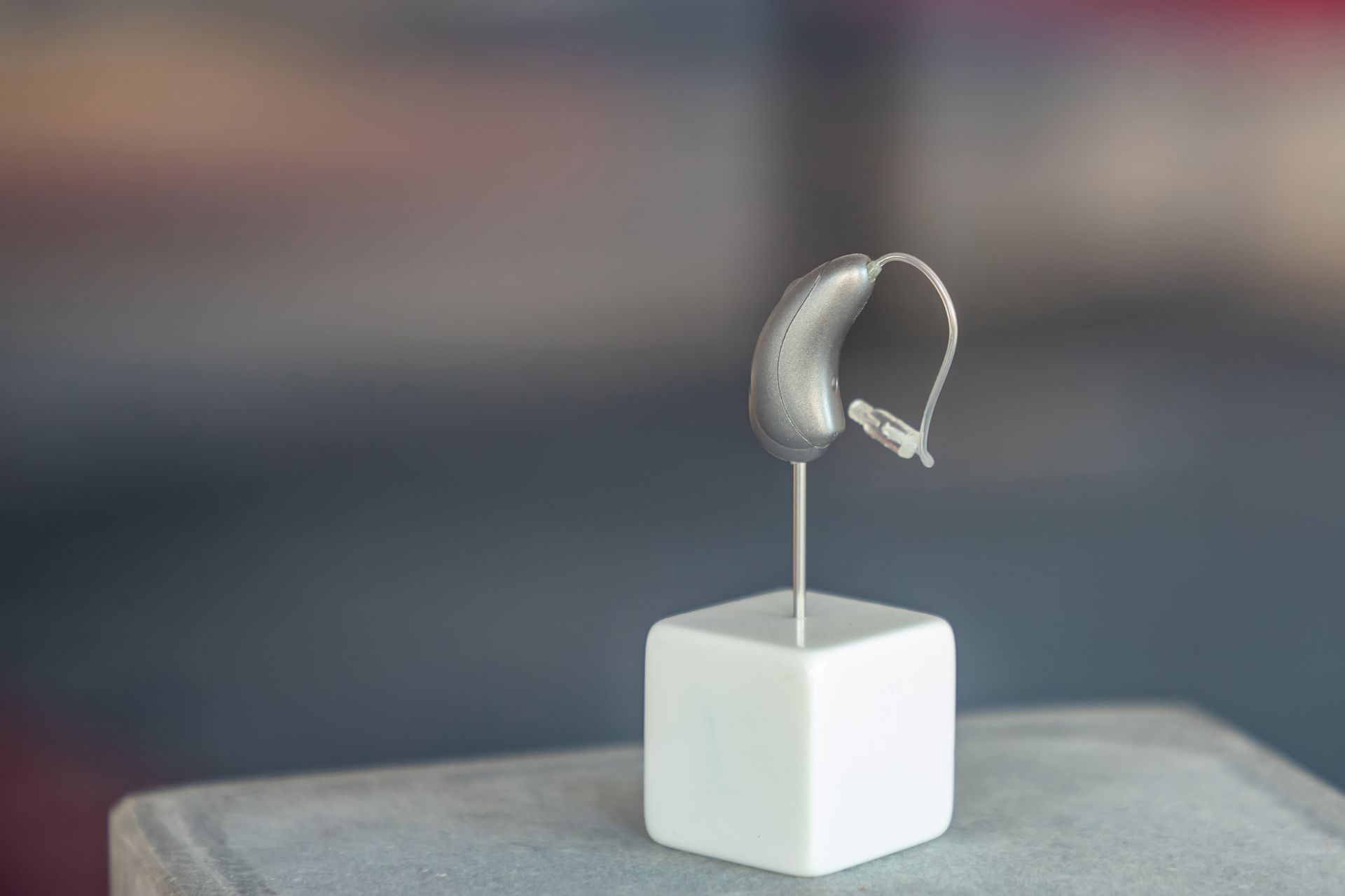 A hearing aid is sitting on top of a white cube on a table.