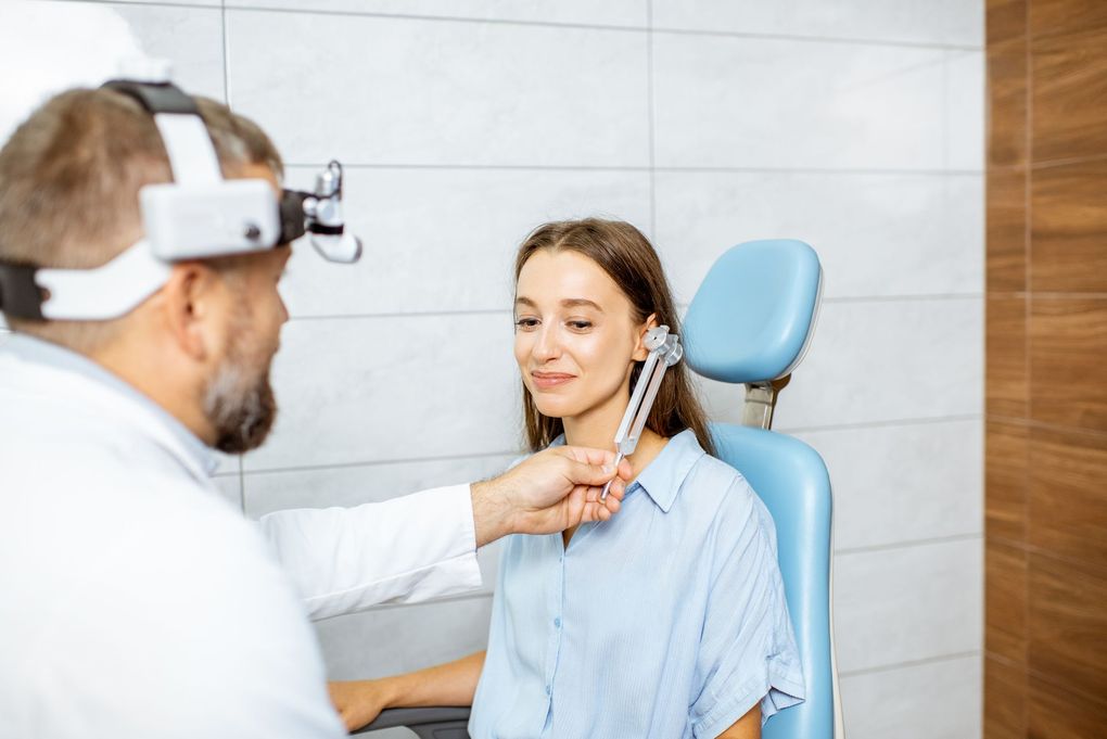 A woman is getting her ears examined by an otolaryngologist.