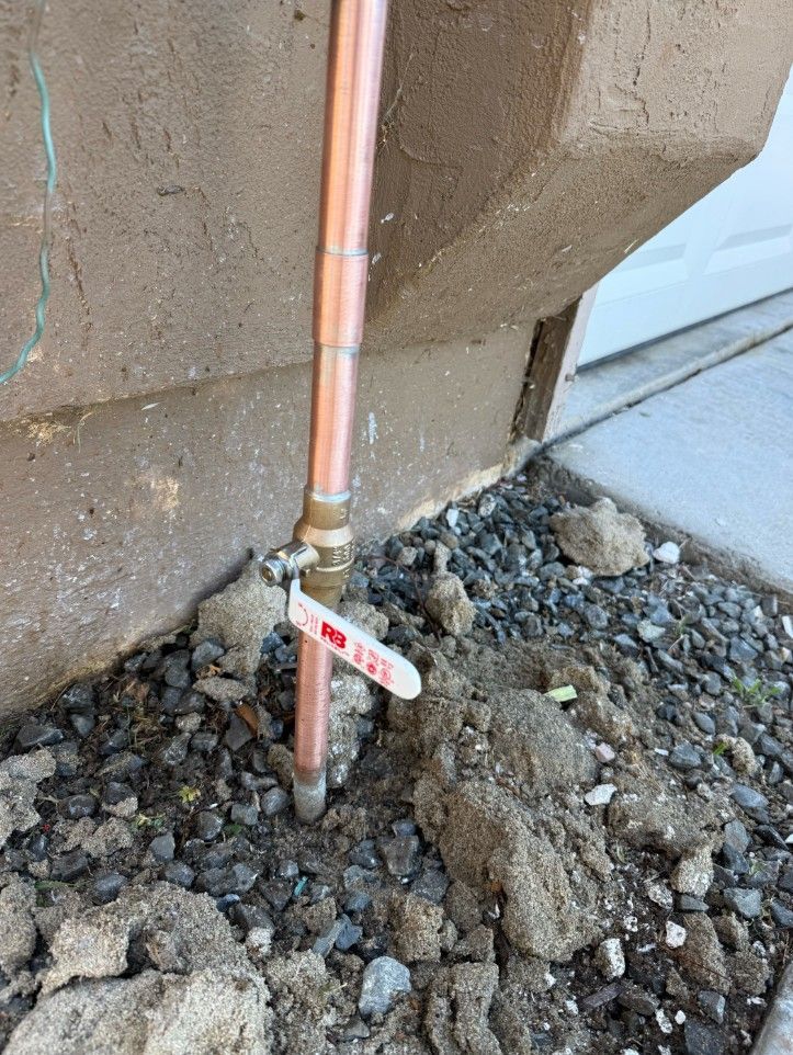 Hands assembling plumbing parts, including a blue connector, black pipe, and red-handled valve.