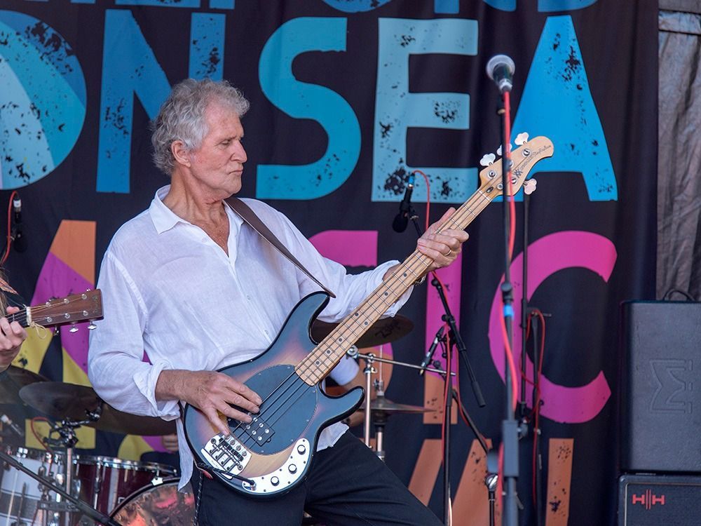 Man playing a bass guitar on stage;