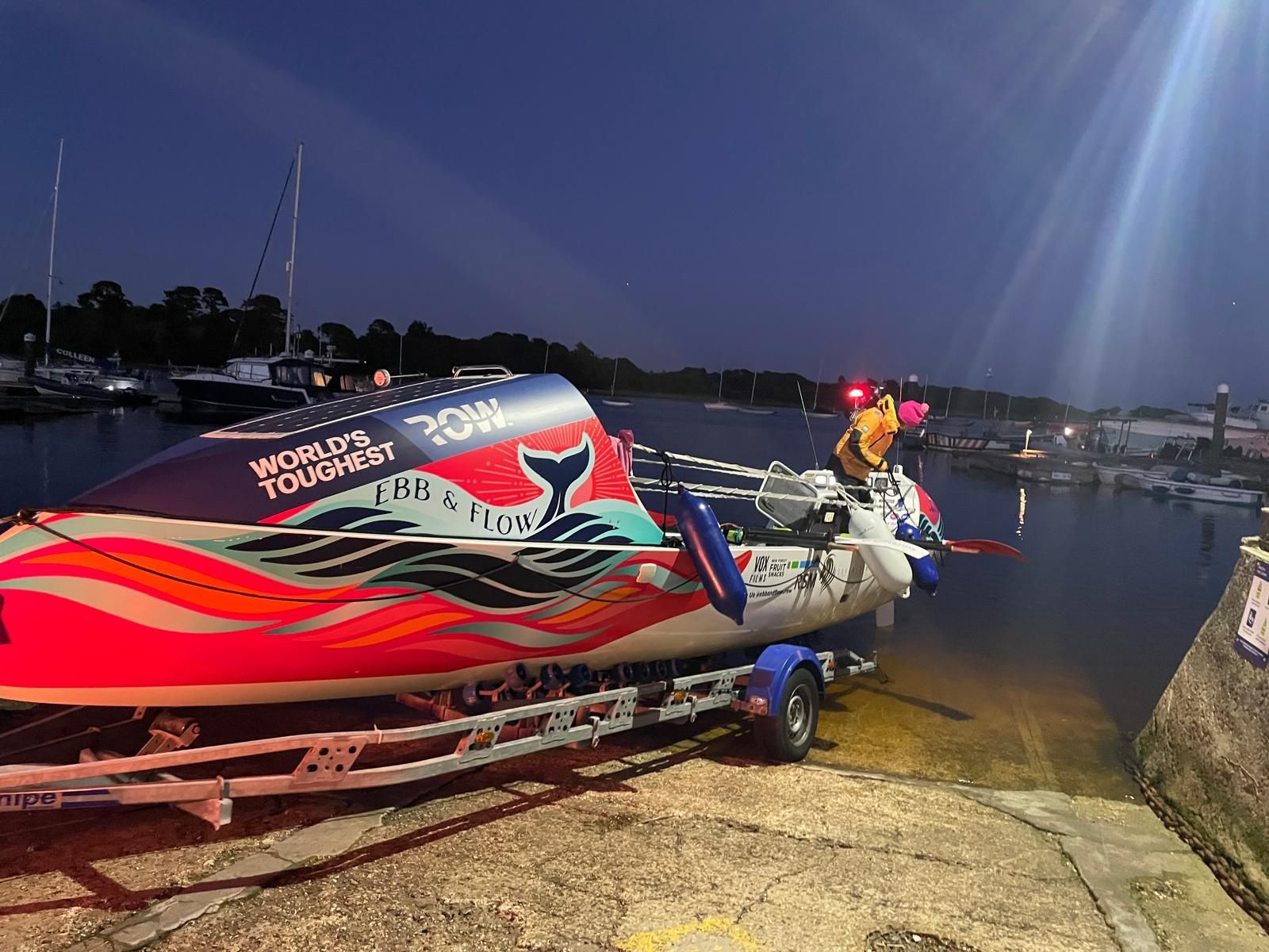 Colorful boat on a trailer at dusk, featuring a whale design and