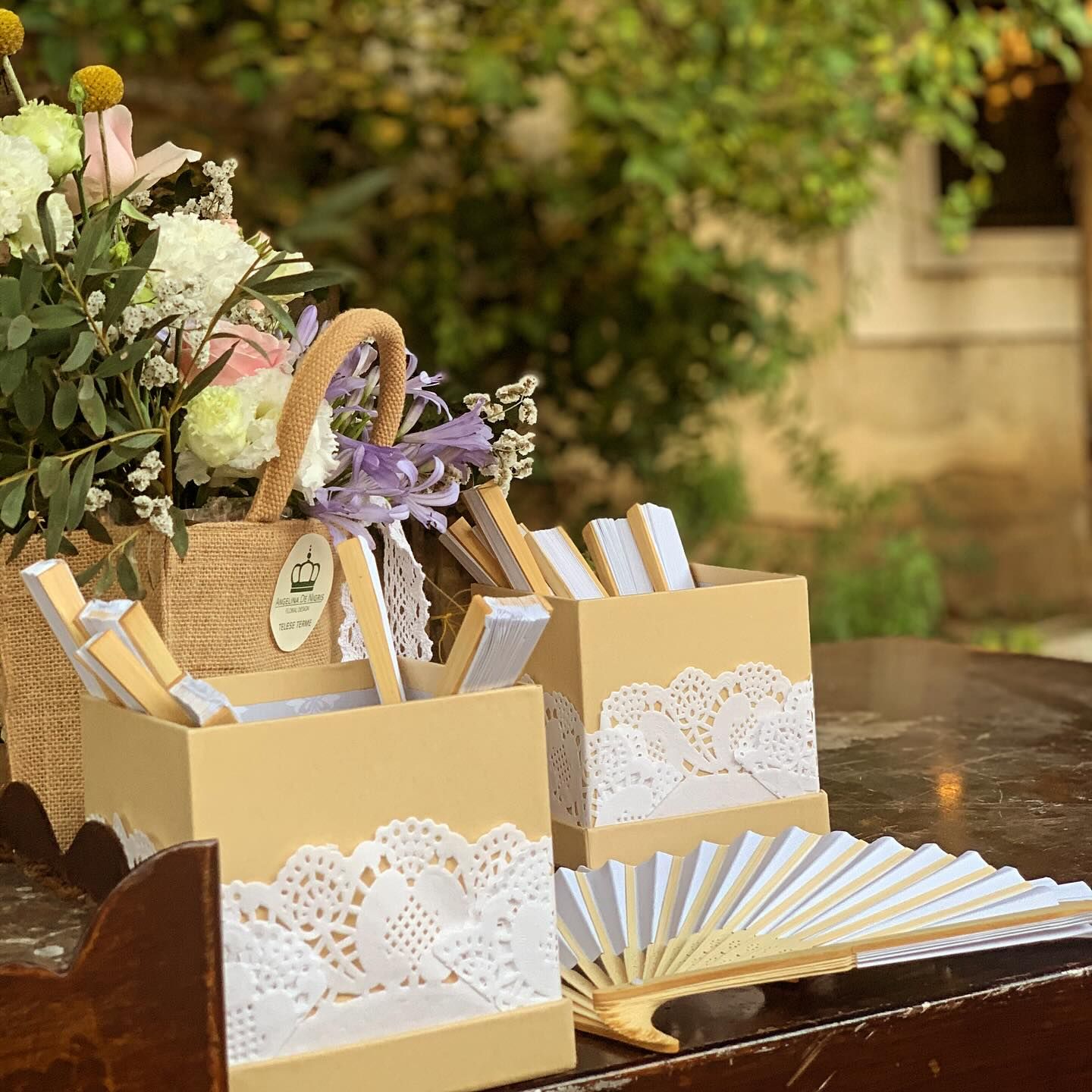 Un fan è seduto su un tavolo accanto a un cesto di fiori