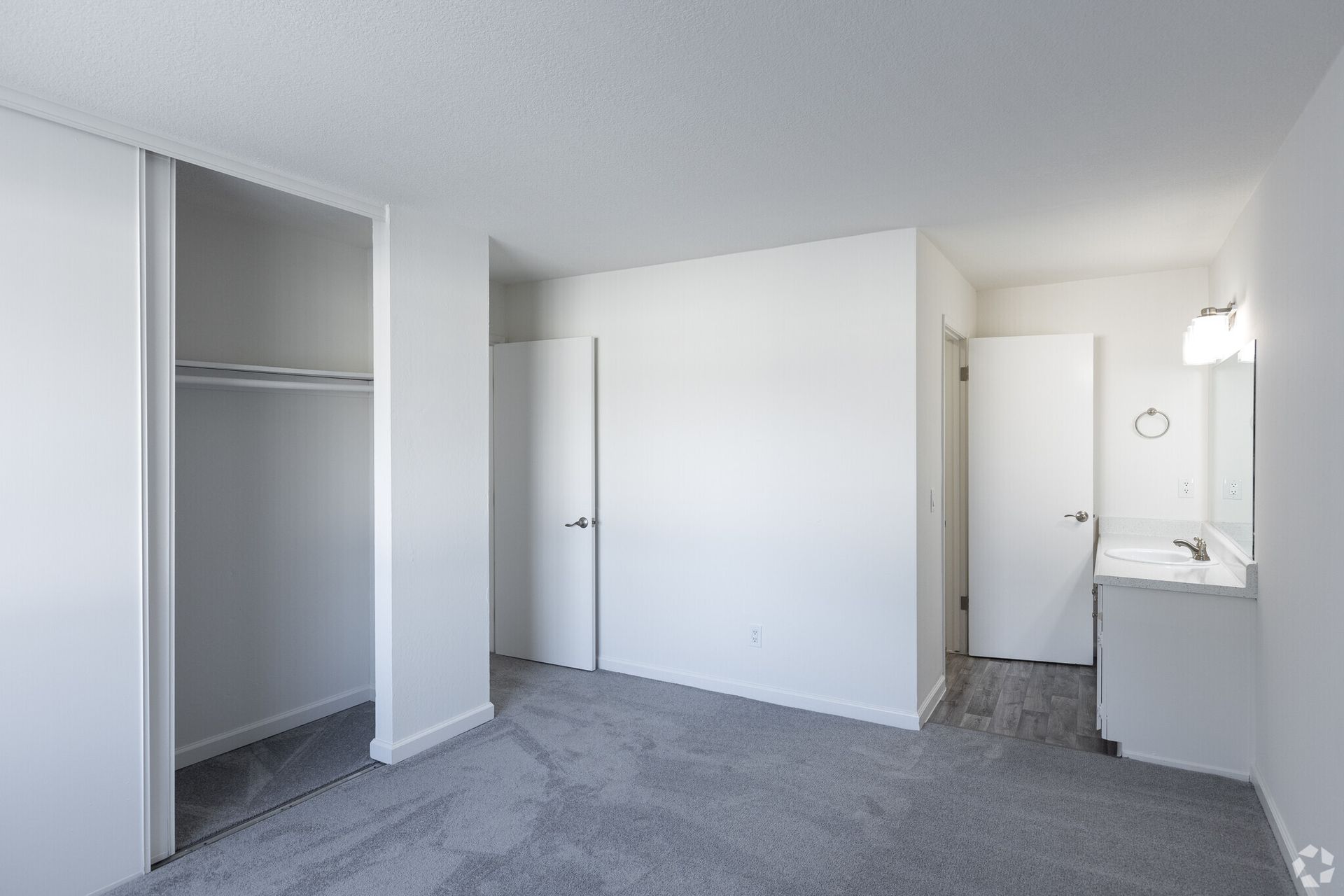An empty bedroom with a closet and a sink
