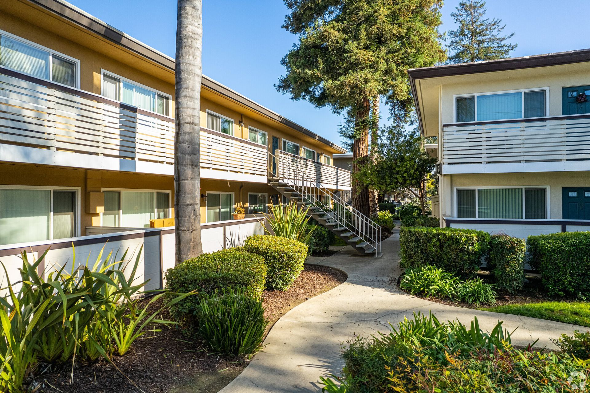 There is a walkway between two apartment buildings.