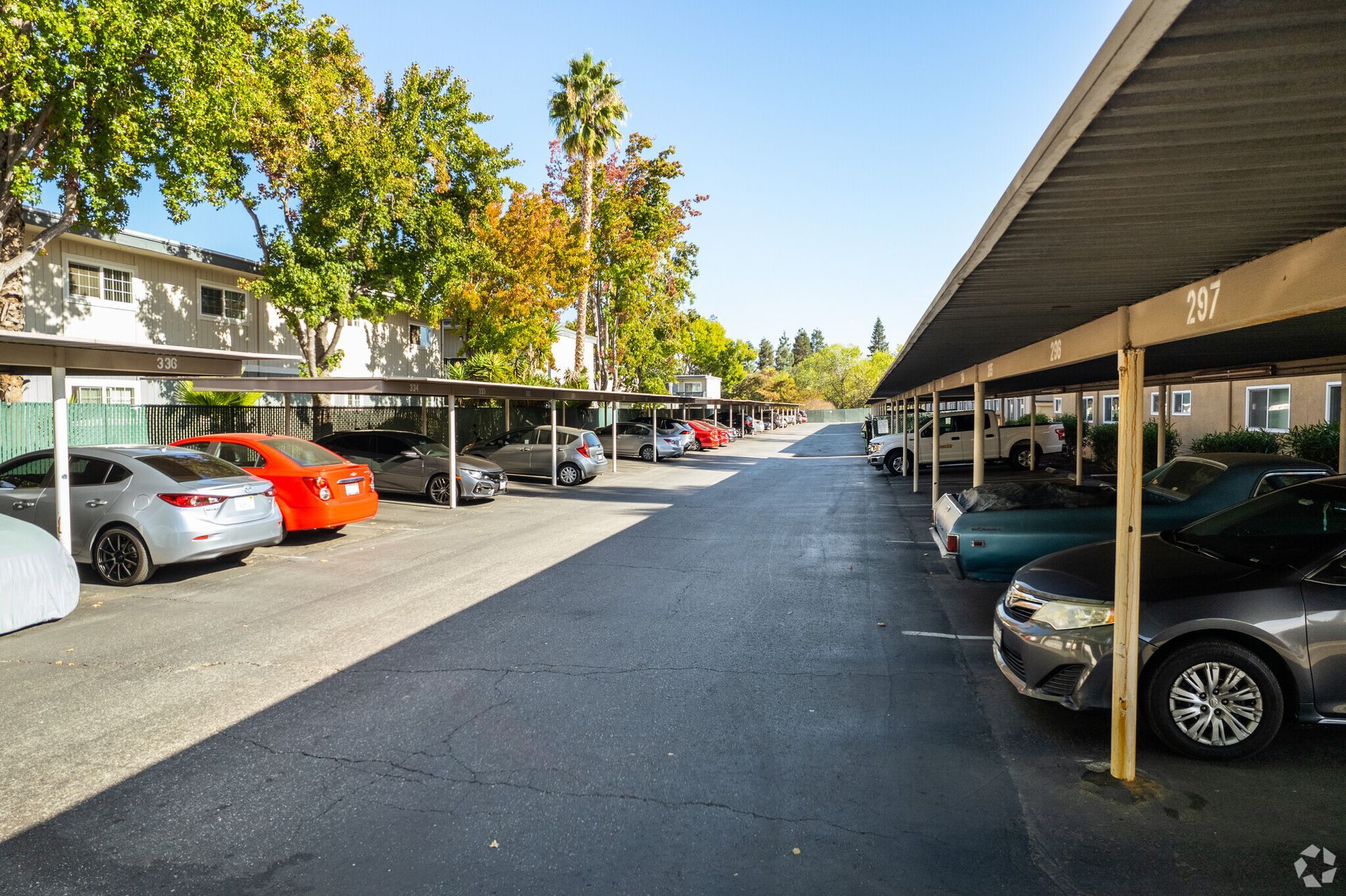 A lot of cars are parked under covered parking lots