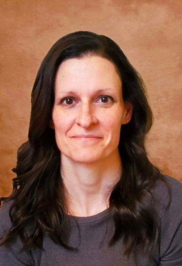 A woman with long dark hair is smiling for the camera.