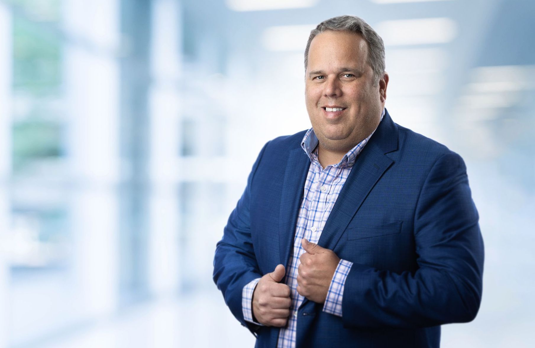 A man in a blue suit is smiling for the camera