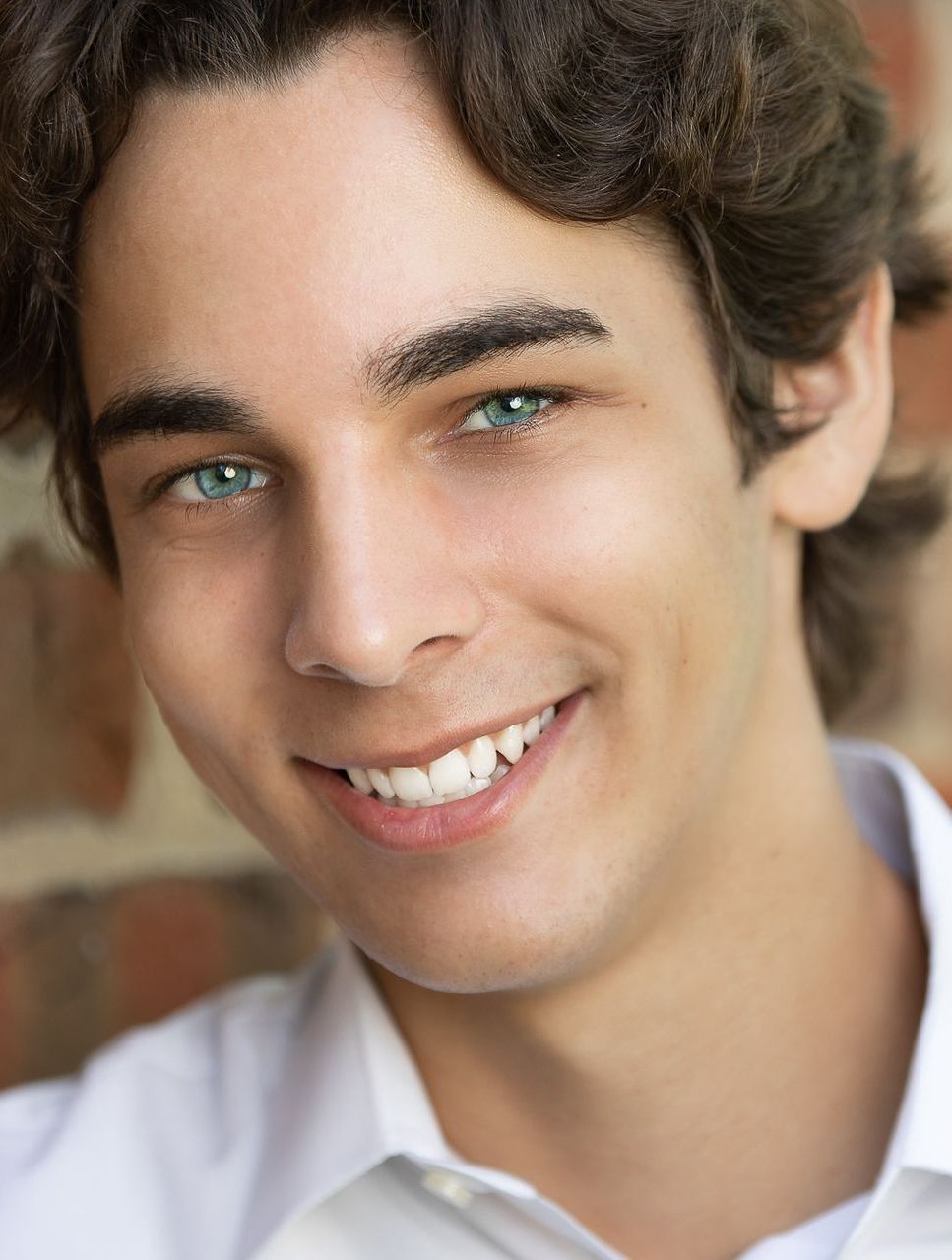 A young man with blue eyes is smiling for the camera