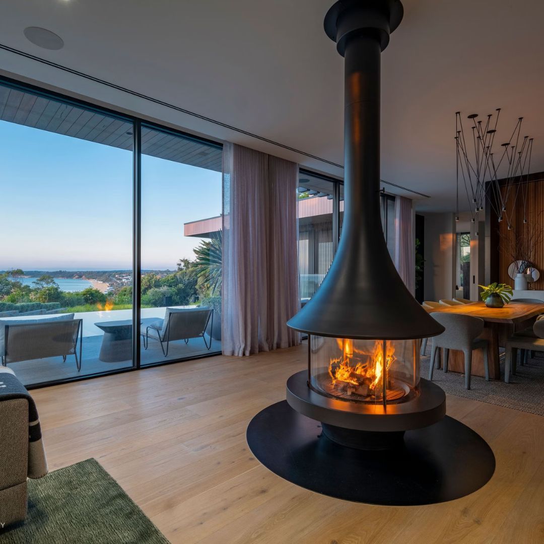A Modern Living Room Features a Suspended Central Fireplace — Complete Heating In Huntingfield, TAS