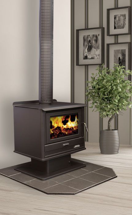 A lit Black Cast-iron Wood Stove Sits on a Hearth Pad — Complete Heating In Huntingfield, TAS