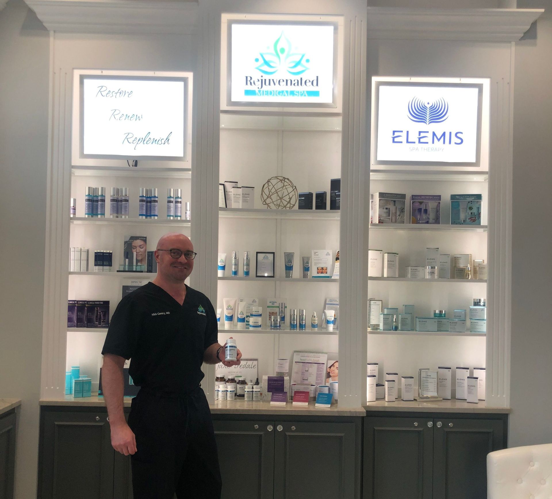 A man stands in front of a display of elemis products