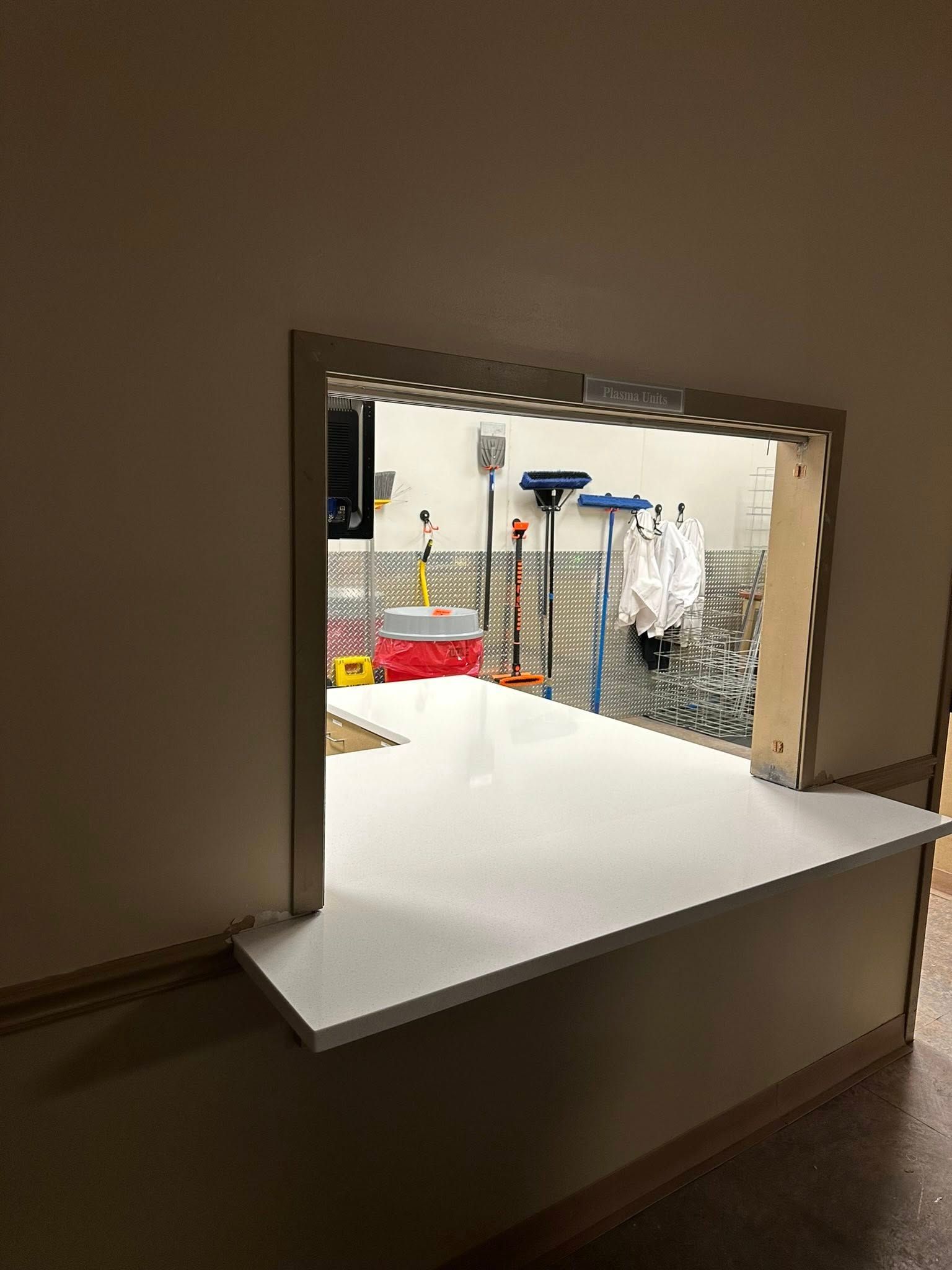 There is a window in the wall that looks out to a garage.